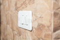 A white light switch on a grey wall Royalty Free Stock Photo