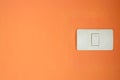 White light switch, turn on or turn off the lights on orange wall. Royalty Free Stock Photo