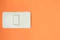 White light switch, turn on or turn off the lights on the orange wall Royalty Free Stock Photo