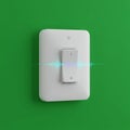 White light switch on a vibrant green wall. The switch features a sleek design with a Royalty Free Stock Photo