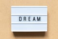 White light box with word dream on wood background