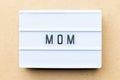 White light box with word mom on wood background Royalty Free Stock Photo