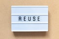 White lightbox with word reuse on wood background Royalty Free Stock Photo