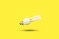 White lightbulb floating on a yellow background with shadow