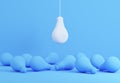 White lightbulb hanging above blue lightbulbs laying on floor.