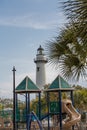 White Lighthouse Beyond Playground Royalty Free Stock Photo