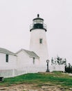 A white lighthouse with a white fence - Pemaquid Point Lighthouse in Bristol, Maine Royalty Free Stock Photo