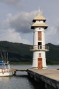 White lighthouse on the fishing pier at the tropical Koh Chang Island, Thailand.