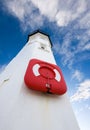 White lighthouse with lifering and blue skies