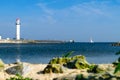 White lighthouse located on a seaside on sunny day. Symbol of in