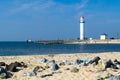 White lighthouse located on a seaside on sunny day. Symbol of in