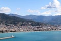 White lighthouse on the pier in Alanya port in Turkey surrounded by azure water of mediterranean sea