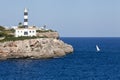 White lighthouse on rocks in the sea ocean water sky blue Royalty Free Stock Photo