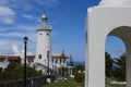 White lighthouse by rotunda in Greek architectural style. Tropical place resort with sea view.