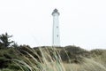 White lighthouse by the sea and grass in the foreground Royalty Free Stock Photo