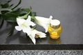 White lilies and candle on black granite tombstone. Funeral ceremony