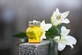 White lilies and candle on grey granite tombstone. Funeral ceremony