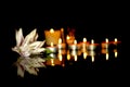 White lily, candles of a funeral on a plaque with the reflection of lights. Mourning background