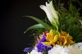 White lilyes, yellow and pink orchids, branch of lilac, chrysanthemums in the spring  tender bouquet on the background with black Royalty Free Stock Photo
