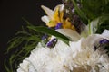 White lilyes, yellow and pink orchids, branch of lilac, chrysanthemums in the spring  tender bouquet on the background with black Royalty Free Stock Photo