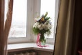 White lilyes, yellow and pink orchids, branch of lilac, chrysanthemums in the spring  tender bouquet on the background with window Royalty Free Stock Photo