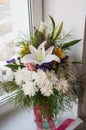 White lilyes, yellow and pink orchids, branch of lilac, chrysanthemums in the spring  tender bouquet on the background with window Royalty Free Stock Photo