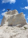 White limestone rock. Tree that grows on top of the rock. Beautiful monument of nature and humanity. Clear blue sky with white