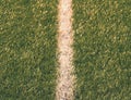 White line marks painted on artificial green turf background. Playfield border. Royalty Free Stock Photo