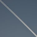 A white line of smoke diagonally across the dark blue sky Royalty Free Stock Photo