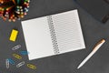 White line spiral paper notebook with mobile phone, pen, colored pencils, eraser and paper clips on dark background Royalty Free Stock Photo