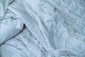 White linen blanket in hotel bedroom. Close up detail of messy white blanket after waking up in morning. Comfortable bed Royalty Free Stock Photo