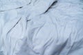 White linen blanket in hotel bedroom. Close up detail of messy white blanket after waking up in morning. Comfortable bed with soft