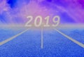 White lines and racetrack, blue asphalt and lush green lawns and Purple Sky, into New Year 2019 Royalty Free Stock Photo