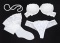 White lingerie set and pearl strand on black background