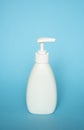 White liquid container, Cosmetic plastic bottle for gel, lotion, cream, shampoo, bath foam with dispenser pump on blue Royalty Free Stock Photo