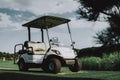 White Little Cart on Golf Field in Sunny Day. Royalty Free Stock Photo