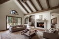 White living room with burning fireplace, white sofas and table covered with interior decorations.