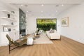 a white living room with wood flooring and a fireplace