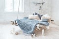 White loft interior in classic scandinavian style. Hanging bed suspended from the ceiling. Cozy large folded gray plaid