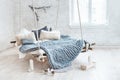 White loft interior in classic scandinavian style. Hanging bed suspended from the ceiling. Cozy large folded gray plaid Royalty Free Stock Photo