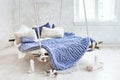 White loft interior in classic scandinavian style. Hanging bed suspended from the ceiling. Cozy large folded violet plaid, giant Royalty Free Stock Photo