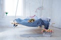 White loft interior in classic scandinavian style. Hanging bed suspended from the ceiling.