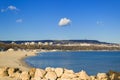 White lonely cloud high in the blue sky over Varna city and the Bay of Varna on a sunny windless day. Empty winter beach on the Bl Royalty Free Stock Photo