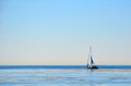 A white lonely yacht is sailing along the shoreline