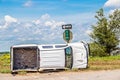 White long cab pick up truck turned on its side in a wreck at an intersection in the country beside a stop sign Royalty Free Stock Photo