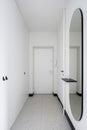 White, long corridor with modern round mirror Royalty Free Stock Photo