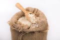 White long rice in burlap sack with wooden spoon