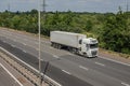White lorry with shipping container in motion on the motorway Royalty Free Stock Photo