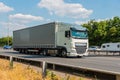White lorry speeding on the motorway against the blue and cloudy sky Royalty Free Stock Photo
