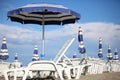 White loungers and blue beach umbrellas on beach Royalty Free Stock Photo